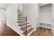Elegant staircase with wooden steps, iron railings, and a convenient coat rack near the entrance at 423 Shallowford Dr, Rock Hill, SC 29732