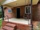 Covered front porch with brick steps and porch swing, perfect for relaxing outdoors at 5068 King Wilkinson Rd, Denver, NC 28037