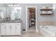Bright bathroom with a granite vanity, a soaking tub, and an open closet for plenty of storage space at 5130 Mount Clare Ln, Charlotte, NC 28210