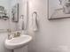 Powder room featuring pedestal sink, decorative mirror, and neutral paint at 5130 Mount Clare Ln, Charlotte, NC 28210