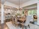 Open-concept dining area with a wooden table, chandelier lighting, and seamless flow to the living spaces at 5130 Mount Clare Ln, Charlotte, NC 28210