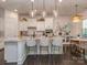 Stylish kitchen featuring a marble island, pendant lights, seating, and open access to dining area at 5130 Mount Clare Ln, Charlotte, NC 28210