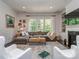 Cozy living room featuring a sectional sofa, large windows, fireplace, and built-in shelving units at 5130 Mount Clare Ln, Charlotte, NC 28210