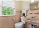 Vintage bathroom features pink tiling, a window, and vintage fixtures with a classic charm at 514 W Sumter St, Shelby, NC 28150