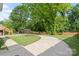 Wide cement driveway surrounded by lush trees, foliage and greenery at 514 W Sumter St, Shelby, NC 28150