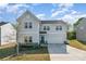 Charming two-story home features a teal door, stone accents, and a well-maintained front yard on a sunny day at 518 Dutch White Dr, Clover, SC 29710
