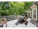 This spacious gray wood deck has a table with seating and opens to the lush green trees at 5617 Sugarcane Ct, Mint Hill, NC 28227