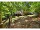 The expansive backyard features a creek, mature trees, and a wooden fence for privacy at 5617 Sugarcane Ct, Mint Hill, NC 28227