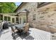 Backyard wooden deck with table and chairs outside a brick home with a screened-in porch at 5617 Sugarcane Ct, Mint Hill, NC 28227