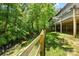 Backyard featuring a wooden fence, creek, and green grass running next to the house at 5617 Sugarcane Ct, Mint Hill, NC 28227