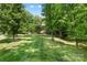 A sprawling backyard with lush grass, trees, and a view of the home's back exterior at 5617 Sugarcane Ct, Mint Hill, NC 28227