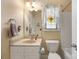 Cozy bathroom featuring a vanity with sink, toilet, and a shower-tub combo, illuminated by sconce lighting at 5617 Sugarcane Ct, Mint Hill, NC 28227