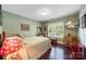 Cozy bedroom features hardwood floors, soft green walls, and a window allowing for natural light to come in at 5617 Sugarcane Ct, Mint Hill, NC 28227