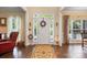 Bright foyer with hardwood floors, a decorative rug, and a white front door with sidelights at 5617 Sugarcane Ct, Mint Hill, NC 28227