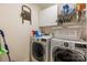 Functional laundry room with washer, dryer, and shelving for storage at 5617 Sugarcane Ct, Mint Hill, NC 28227