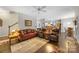 Comfortable living room with hardwood floors, leather furniture, ceiling fan, and open access to the kitchen at 5617 Sugarcane Ct, Mint Hill, NC 28227