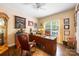 Bright home office with a large wooden desk, leather chair, and natural light from the window at 5617 Sugarcane Ct, Mint Hill, NC 28227