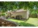 Serene backyard offers artificial turf, mature trees, an outdoor seating area and privacy fence at 5818 Downfield Wood Dr, Charlotte, NC 28269
