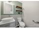 Stylish half bath with decorative vessel sink, vintage wood shelves, and designer mirror at 5818 Downfield Wood Dr, Charlotte, NC 28269