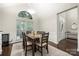 Bright dining room with dark table set for six, large windows, and hardwood floors at 5818 Downfield Wood Dr, Charlotte, NC 28269