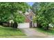 Charming brick two-story home featuring a two-car garage and mature trees at 5818 Downfield Wood Dr, Charlotte, NC 28269