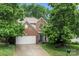 Charming brick two-story home featuring a two-car garage and mature trees at 5818 Downfield Wood Dr, Charlotte, NC 28269