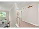 Hallway featuring a window, chandelier, and staircase, provides access to the upper level at 5818 Downfield Wood Dr, Charlotte, NC 28269