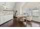 Bright eat-in kitchen with white cabinets, stainless appliances, and hardwood floors at 5818 Downfield Wood Dr, Charlotte, NC 28269