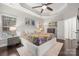 Spacious main bedroom features tray ceiling, fan, and views from the windows at 5818 Downfield Wood Dr, Charlotte, NC 28269