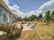 Inviting backyard with a patio and seating, surrounded by lush greenery and blossoming rose bushes at 6266 Swanport Rd, Lancaster, SC 29720