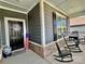 Inviting covered porch offers rocking chairs, views, and an American flag, enhancing the home's curb appeal at 6266 Swanport Rd, Lancaster, SC 29720