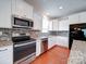 Bright kitchen featuring granite counters, stainless appliances, white cabinetry, and hardwood flooring at 6266 Swanport Rd, Lancaster, SC 29720