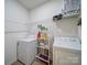 Well-lit laundry room featuring a washer and dryer with ample storage shelving and modern appliances at 6266 Swanport Rd, Lancaster, SC 29720