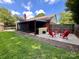 A backyard with a screened porch, a cozy gravel patio, and red outdoor seating for relaxation at 6301 Cherrycrest Ln, Charlotte, NC 28217