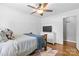 Cozy bedroom features a ceiling fan, white dresser with television, and hardwood floors at 6301 Cherrycrest Ln, Charlotte, NC 28217
