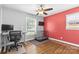 Bedroom with light hardwood floors, a desk and chair by the window, and accent wall at 6301 Cherrycrest Ln, Charlotte, NC 28217