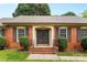 Close up of double front doors with wreaths and manicured shrubs and brick steps at 6301 Cherrycrest Ln, Charlotte, NC 28217