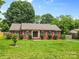 Charming brick home with a lush front lawn, manicured landscaping, and a welcoming entryway at 6301 Cherrycrest Ln, Charlotte, NC 28217