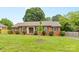Well-maintained brick home featuring mature trees, landscaped yard, and inviting entrance at 6301 Cherrycrest Ln, Charlotte, NC 28217