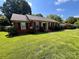 A cozy brick house featuring lush green grass, black shutters, and a well-maintained landscape at 6301 Cherrycrest Ln, Charlotte, NC 28217