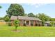 Charming single-story brick home with well-manicured lawn, mature trees and trimmed shrubs at 6301 Cherrycrest Ln, Charlotte, NC 28217