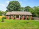 Charming single-story brick home with well-manicured lawn, trimmed shrubs and double front doors at 6301 Cherrycrest Ln, Charlotte, NC 28217