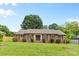 Charming single-story brick home with well-manicured lawn, mature trees and trimmed shrubs at 6301 Cherrycrest Ln, Charlotte, NC 28217