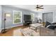 Bright living room featuring wood floors, large windows, a cozy sofa, and modern media center at 6301 Cherrycrest Ln, Charlotte, NC 28217