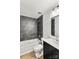 This bathroom showcases dark tiled walls, a shower and tub combination, with modern lighting at 6839 Wagon Oak Rd, Charlotte, NC 28212