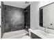 This bathroom features dark tiled walls, a shower and tub combination, and sleek fixtures at 6839 Wagon Oak Rd, Charlotte, NC 28212