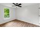 Bedroom with hardwood flooring, a ceiling fan, and a bright window at 6839 Wagon Oak Rd, Charlotte, NC 28212