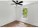 Sun-filled bedroom featuring durable floors, a modern fan, and view to the lush outdoors at 6839 Wagon Oak Rd, Charlotte, NC 28212