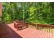 Expansive wooden deck overlooks a lush backyard with mature trees, offering privacy and a natural setting at 6839 Wagon Oak Rd, Charlotte, NC 28212