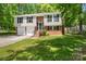 Split-level home features a brick facade, two-car garage, and a well-manicured lawn at 6839 Wagon Oak Rd, Charlotte, NC 28212
